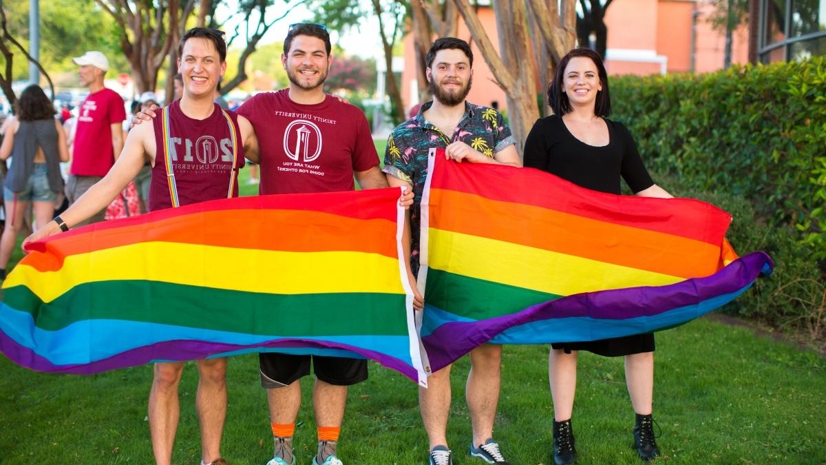 A group of students pose with pride flags